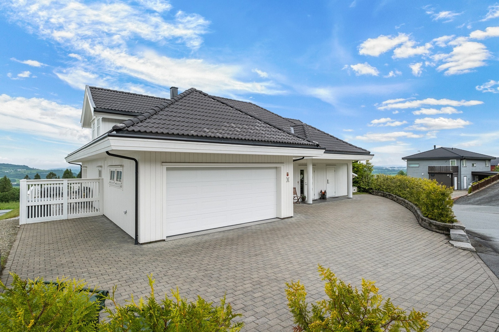 Stilren fasade med moderne preg og praktisk adkomst. Tomten er pent opparbeidet med bl.a støttemurer Galleribilde