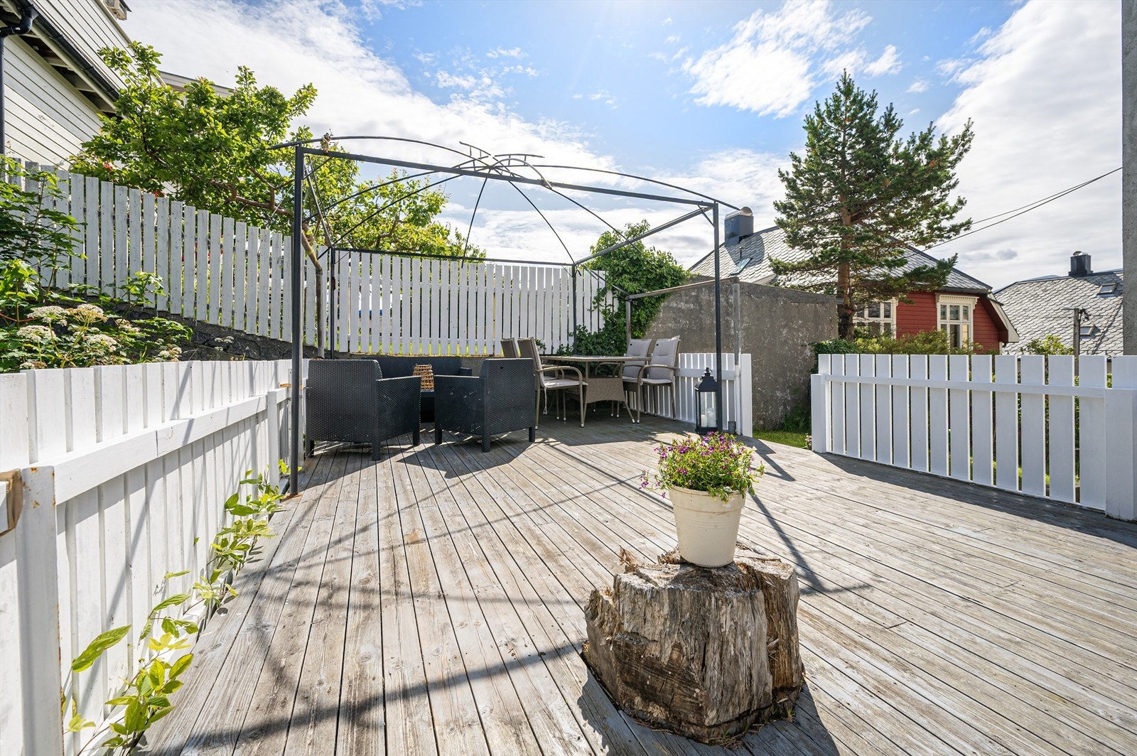 Stor inngjerdet uteplass/markterrasse i hagen med gode muligheter for hyggelig sosialt samvær Galleribilde