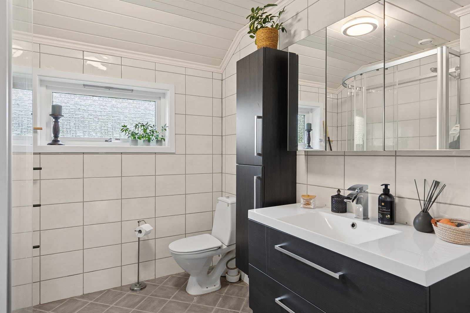 Badet ble renovert i 2011 og fremstår som moderne og funksjonelt. Rommet er innredet med nedfelt servant, toalett og dusjkabinett. Galleribilde