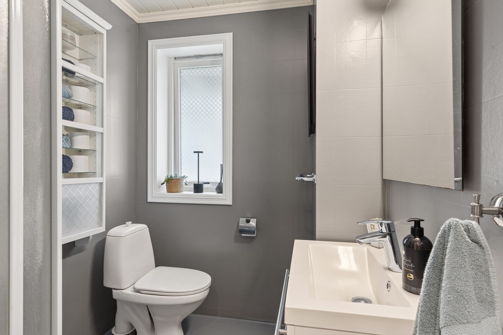 Badet i kjelleren har innredning med servant, toalett og dusjhjørne med vegger. Veggene er belagt med våtromstapet/belegg, og taket har himlingsplater. Galleribilde