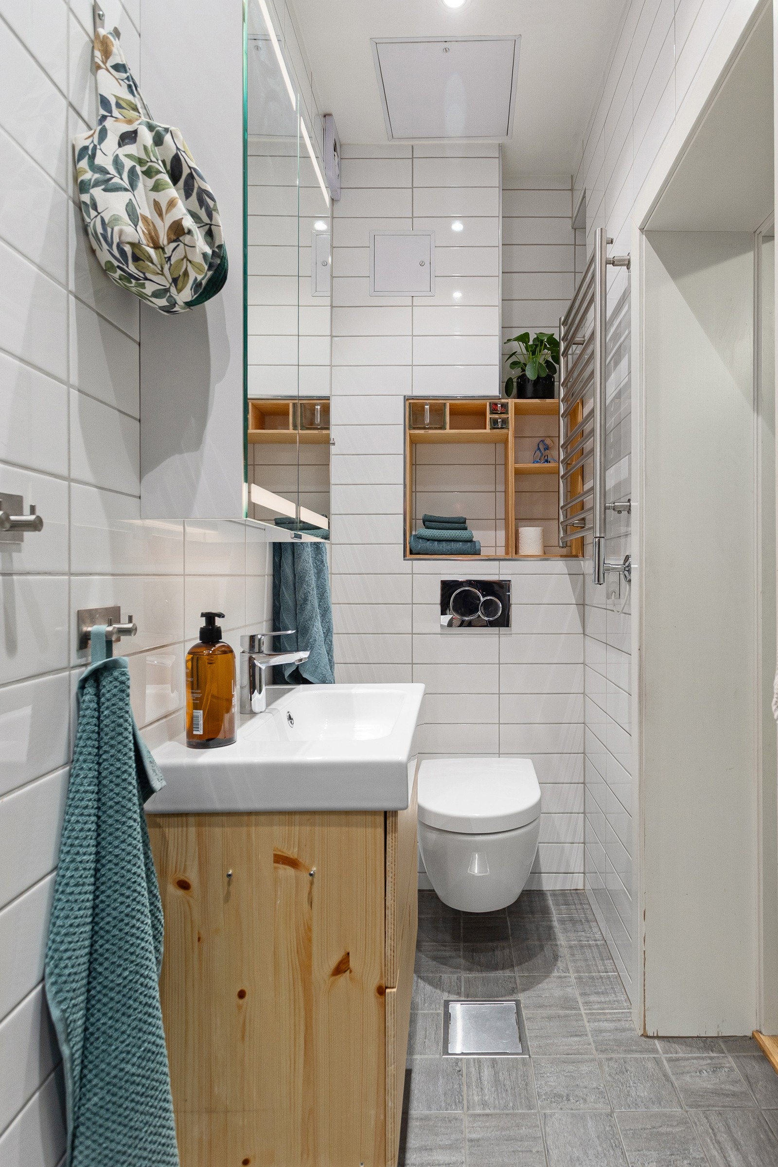 Badet er arealeffektivt innredet med servantskap, nyere speilskap, vegghengt wc og smart nisje over toalettet. Galleribilde