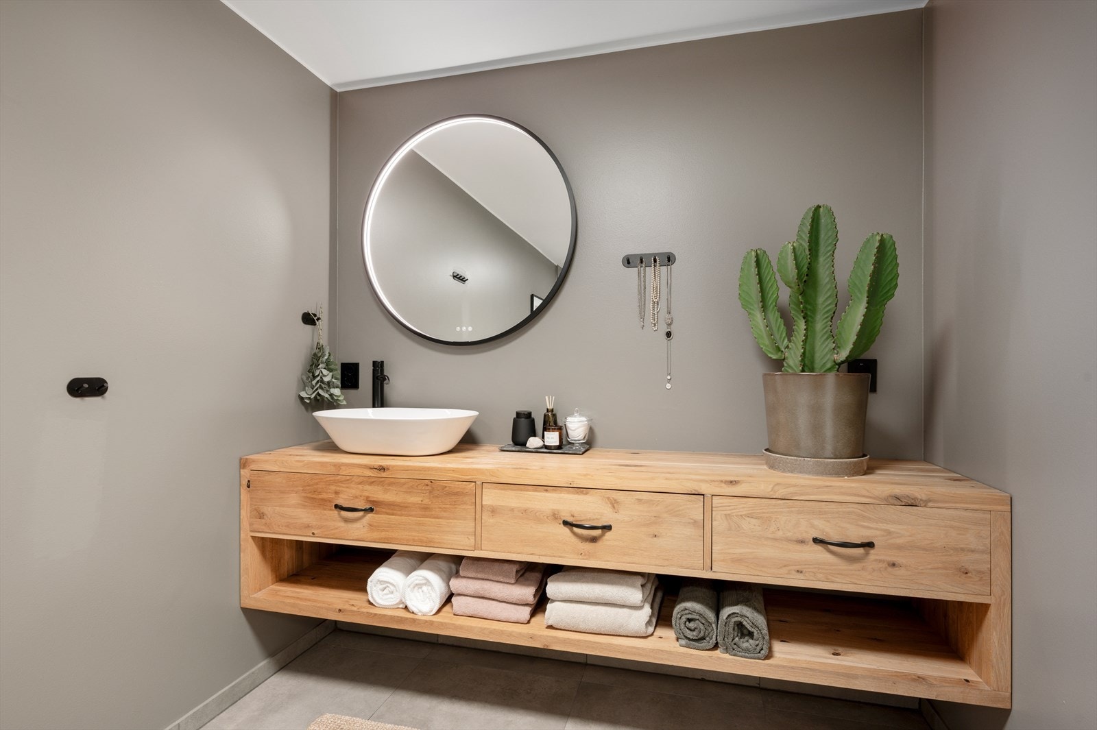 Badet er utstyrt med blant annet gulvvarme badekar, dusjnisje, mekanisk avtrekk, servant, servantskap og veggmontert wc. Galleribilde