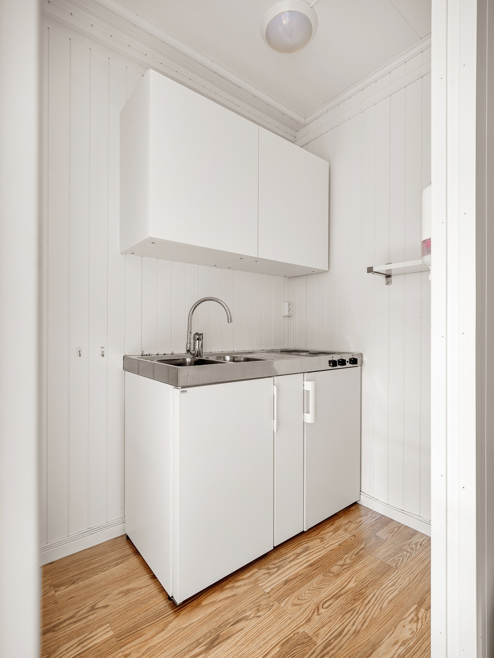 Kjøkken med servant og koketopp. Kjøleskapdel under koketoppen. Galleribilde