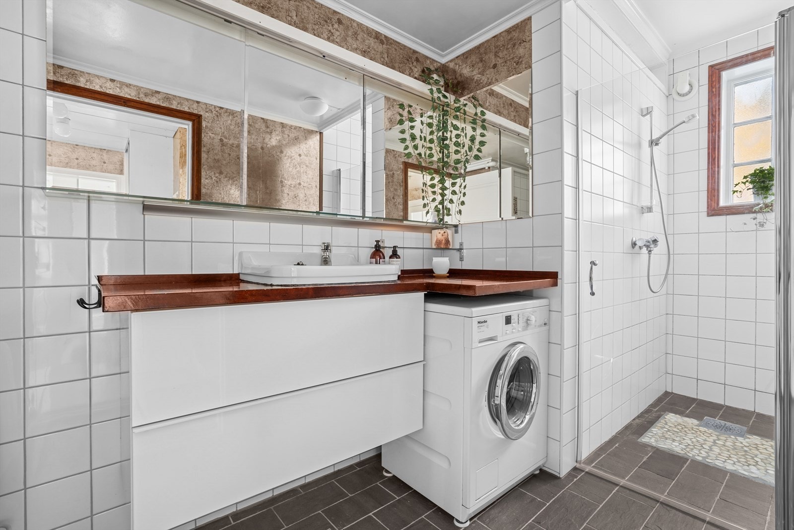 Baderommet er flislagt med egen dusjnisje. Her er det også opplegg for vaskemaskin Galleribilde