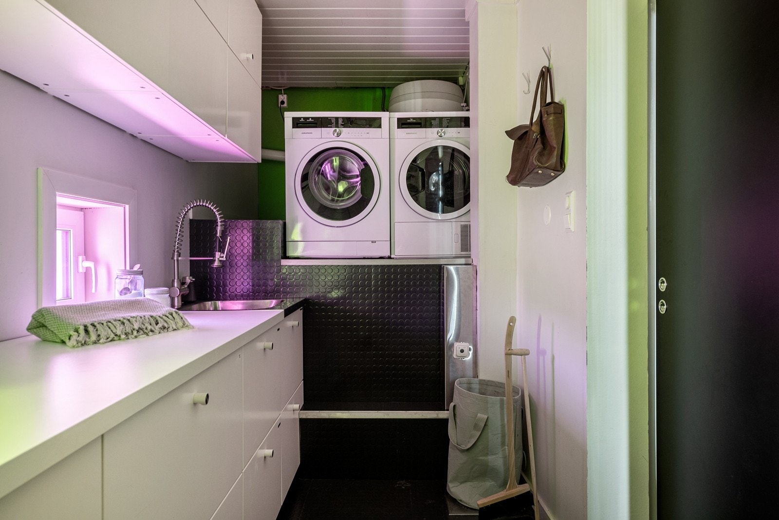 Praktisk vaskerom med god oppbevaring, opphøyde hvitevarer og praktiske løsninger for en effektiv hverdag. Galleribilde