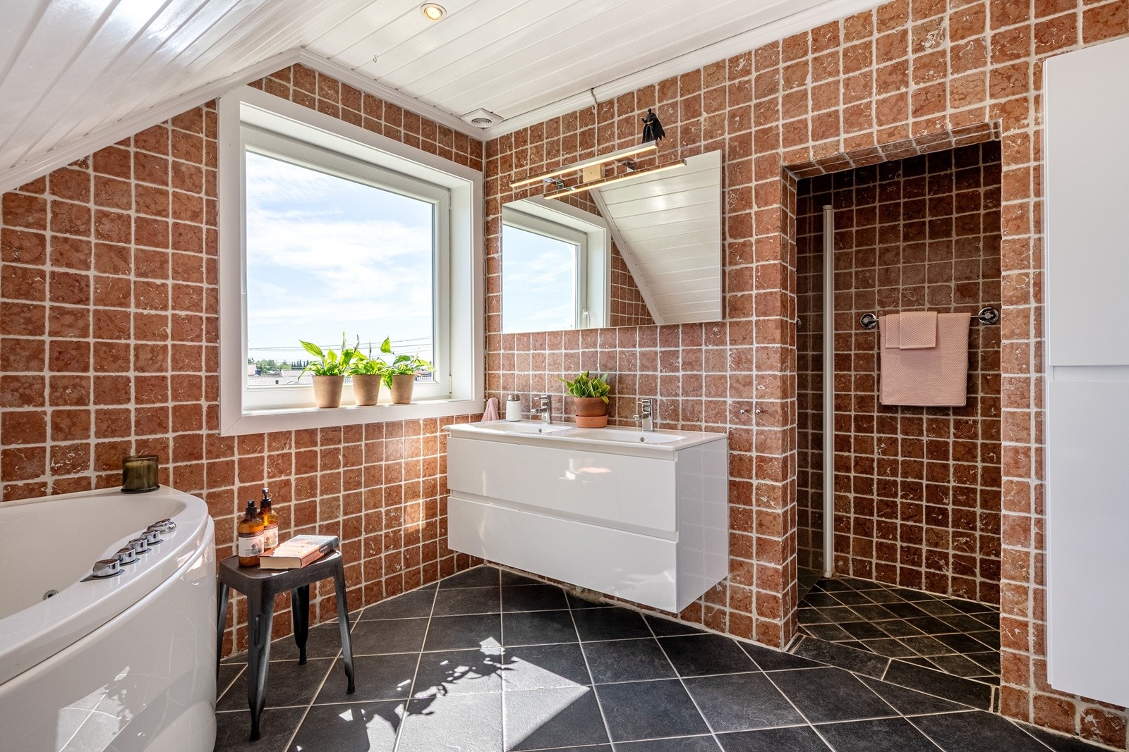 Romslig bad med dobbel vask i innredning, dusjnisje og badekar. Galleribilde