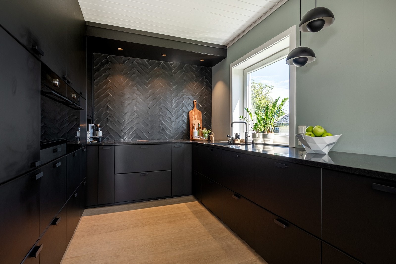 Elegant kjøkken med slitesterk benkeplate i børstet granitt fra Strandberg Stein. Galleribilde