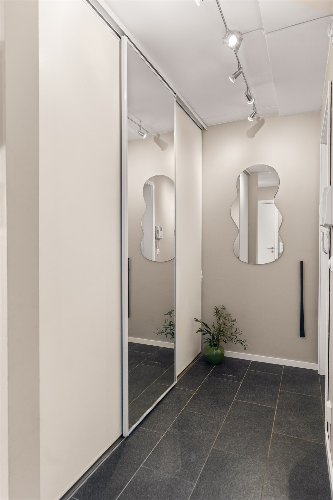 Velkommen inn! Entreen har god plass og en praktisk, integrert skyvedørsgarderobe med speil som gir en ryddig inngangssone. Galleribilde