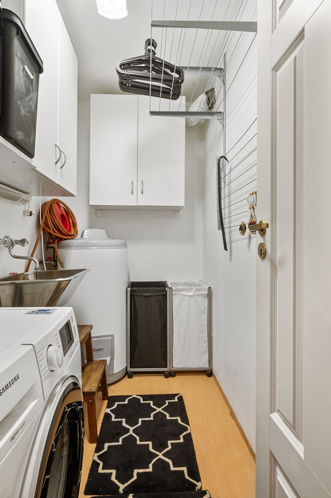 Vaskerommet har sluk, utslagsvask og opplegg for vaskemaskin, samt flere skap og praktiske tørkehyller. Rommet er fra byggeår. Galleribilde