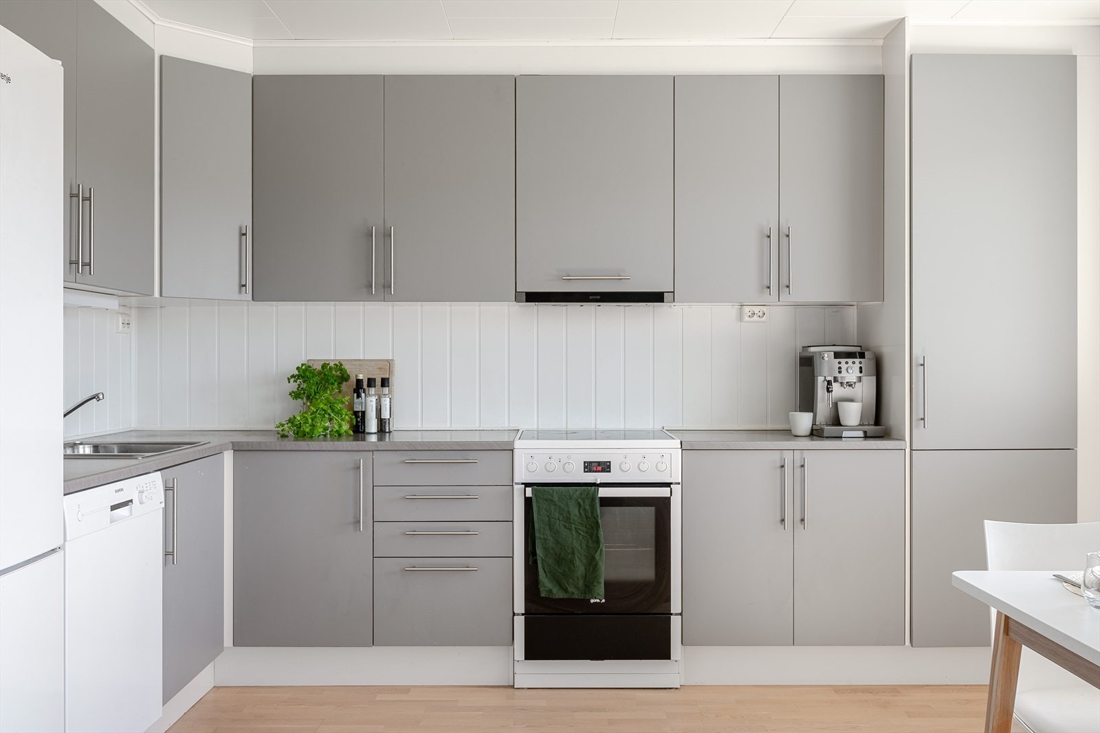 Innredningen har grå glatte fronter og laminert benkeplate med nedfelt oppvaskkum. Galleribilde