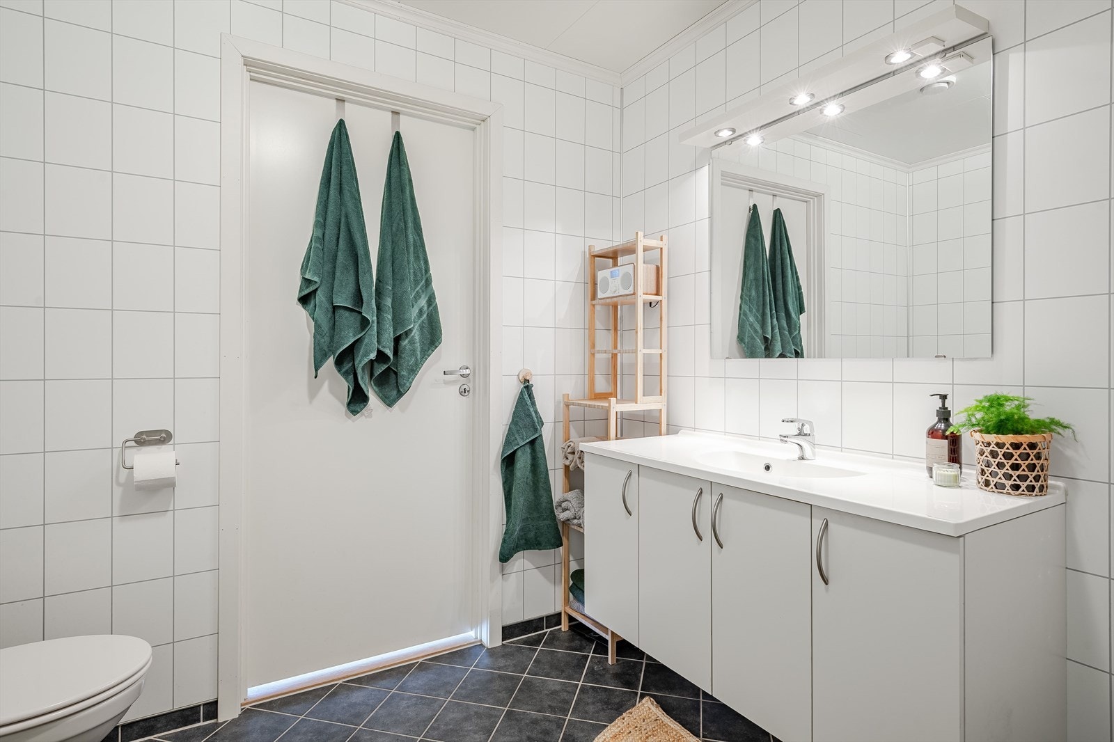 Baderommet er også utstyrt med dusjhjørne med innfellbare glassdører og vegghengt toalett. Galleribilde