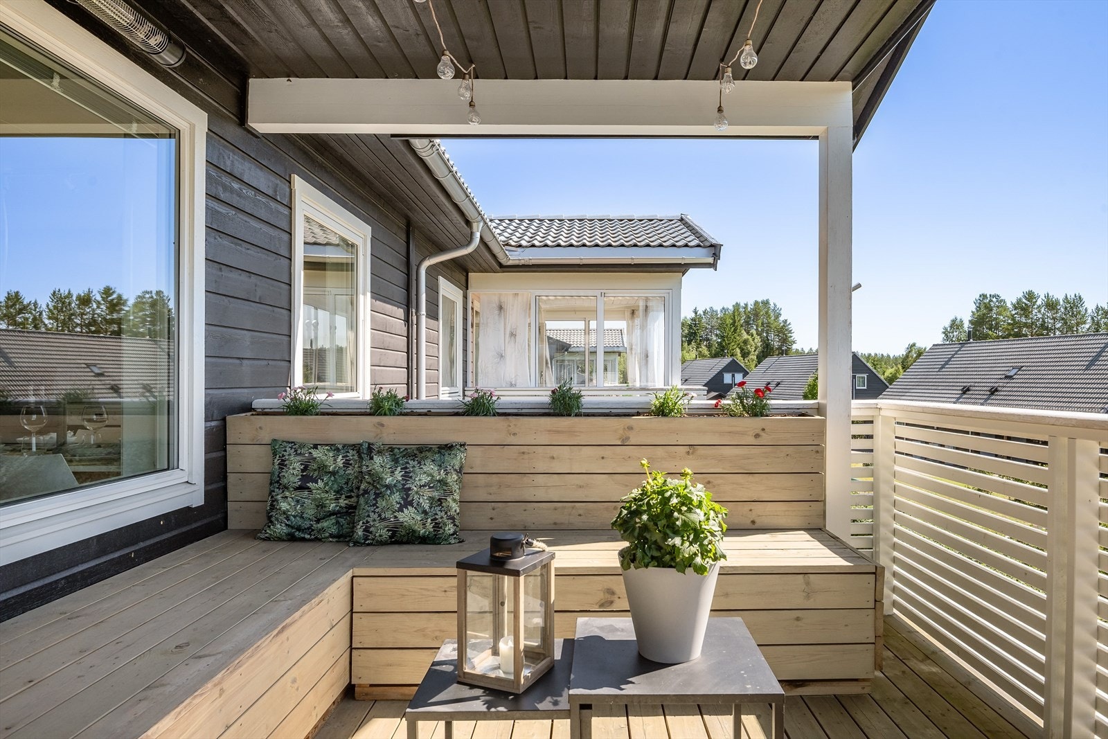 Balkongen er overbygget, har terrassebord på gulv og er utstyrt med en flott plassbygget sittebenk med integrert blomsterkasse. Galleribilde