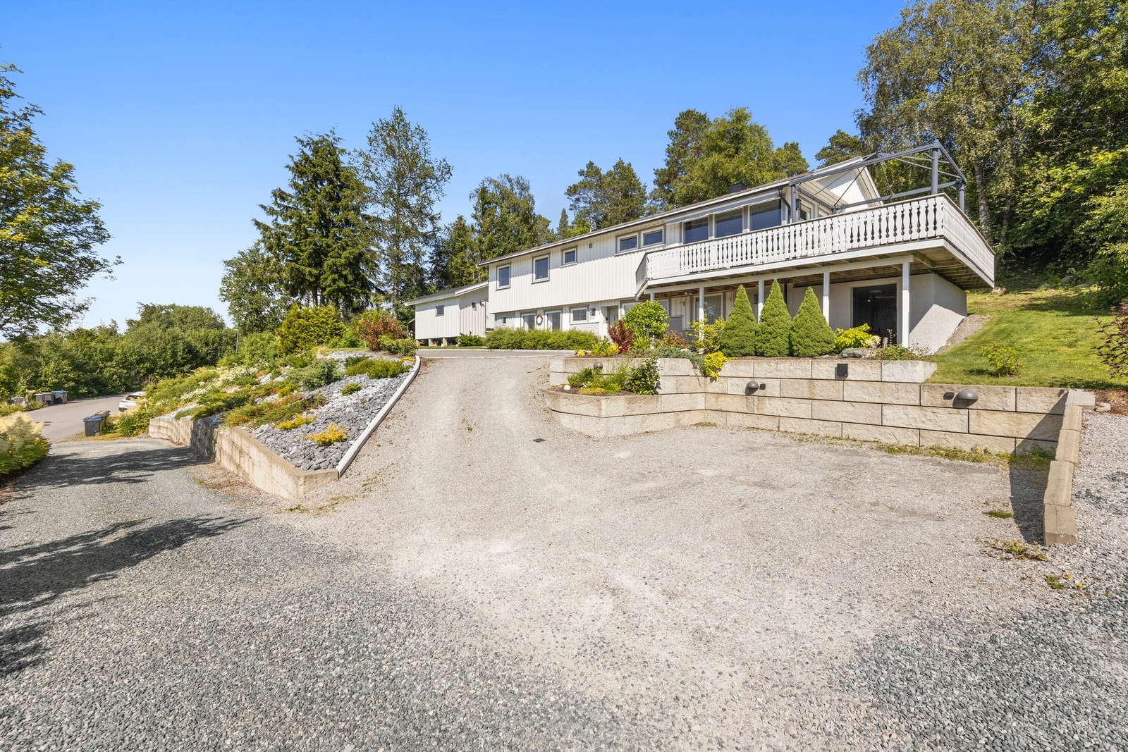 Parkeringsplass som er opparbeidet med støttemur, belysning og tilgang til elbillader Galleribilde