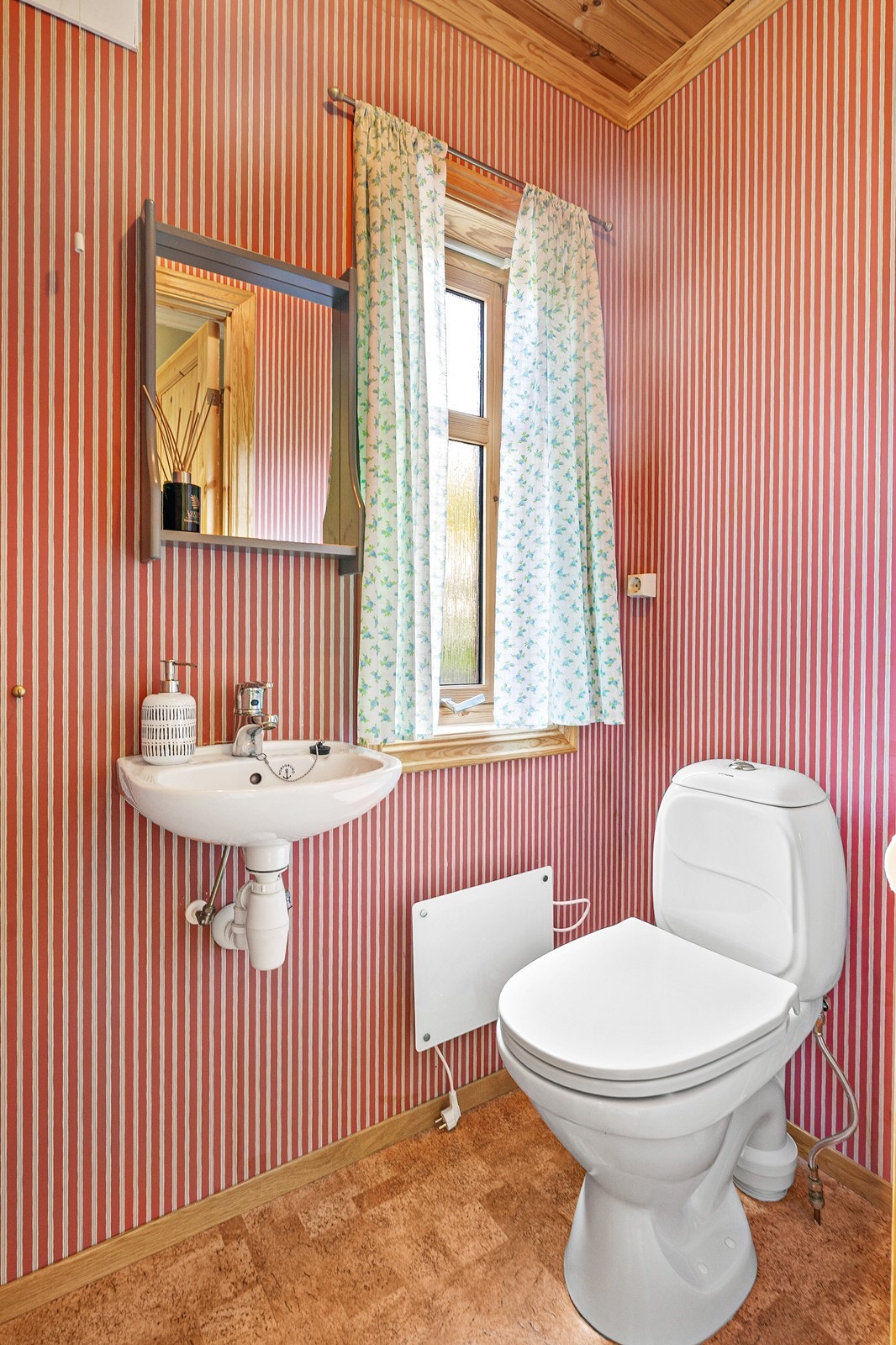 Toalettrommet har gulvbelegg, tapet på vegger og panel i tak. Rommet er innredet med vask og toalett. Det er naturlig ventilasjon. Galleribilde