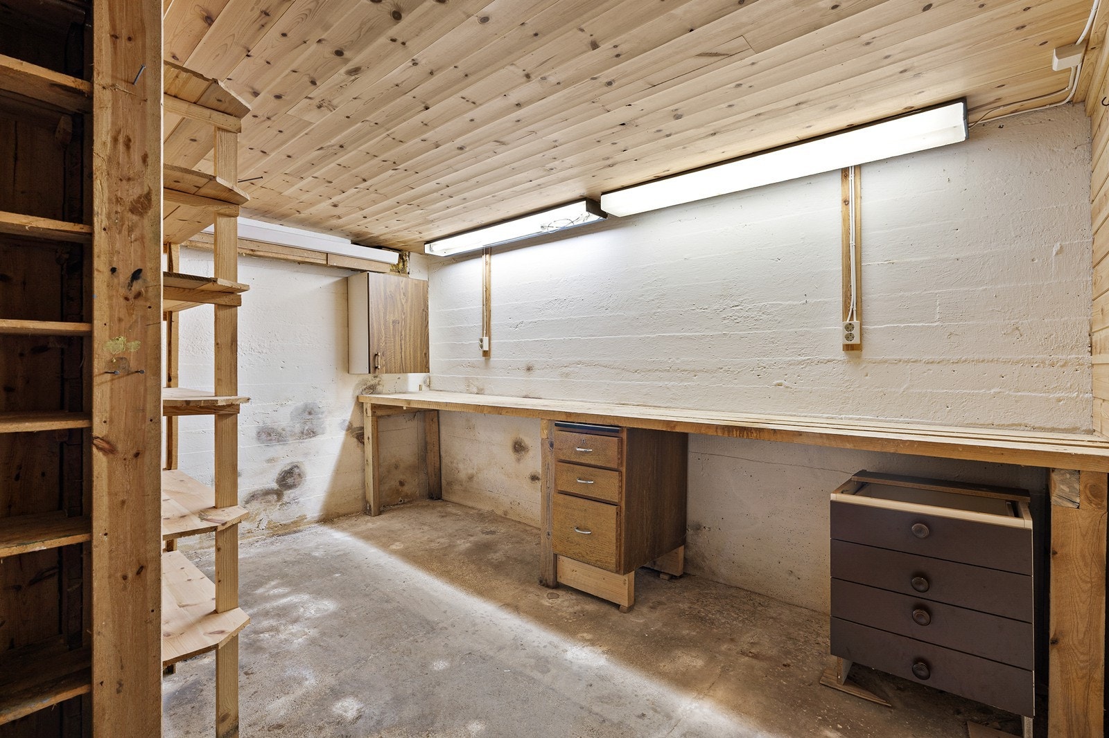 Gulvet er av betong, og veggene har panel og betong/mur. Galleribilde