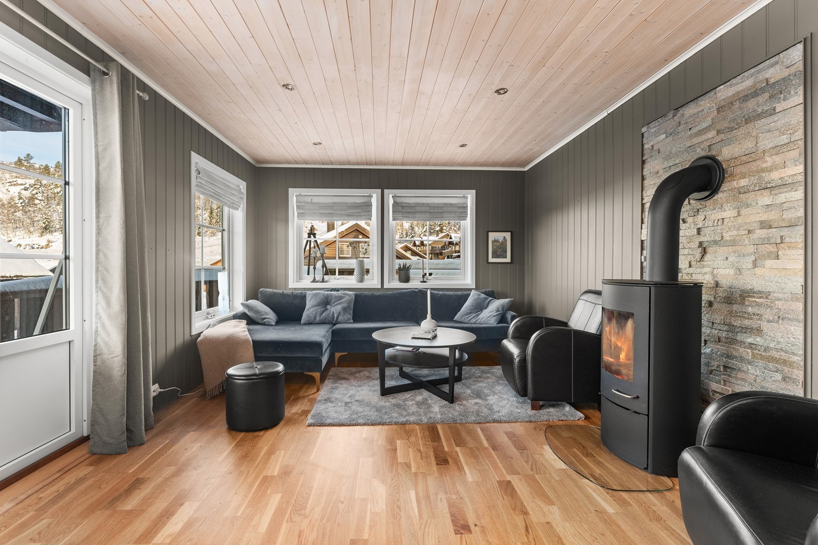 Lys og innbydende stue med store vindusflater og peis. Galleribilde