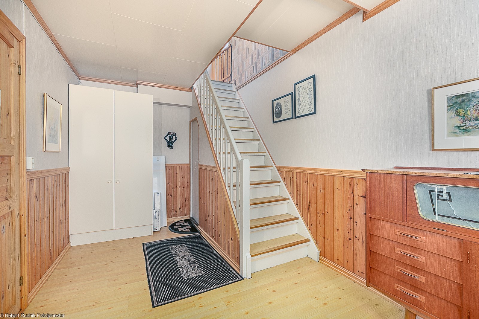 Stor gang med trapp til loft, trapp til kjeller og inngang til kjøkken. Galleribilde