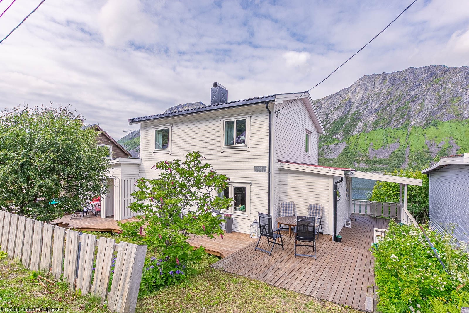 Tomten er pent opparbeidet med plen og platting. Galleribilde