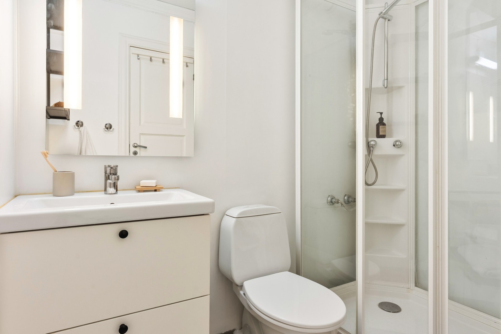 På venstre side av entrédøren ligger badet på 3,4 kvm. Det har fliser på gulv, malte baderomsplater på vegger og er godt utnyttet. Galleribilde