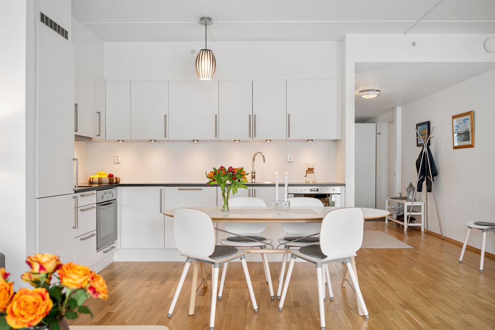 Kjøkkenet har en pen og klassisk innredning med lyse, slette fronter og laminert benkeplate Galleribilde