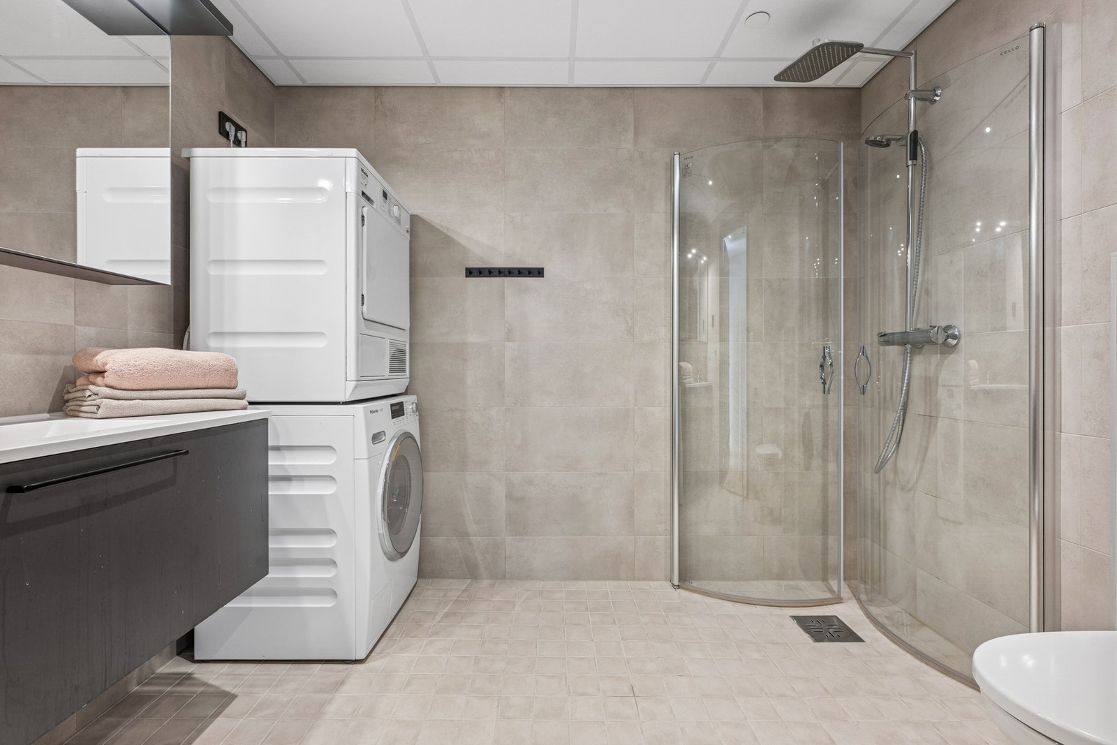 Bad/vaskerom har fliser på gulv og vegger, og det er varmekabler i gulvet. Galleribilde