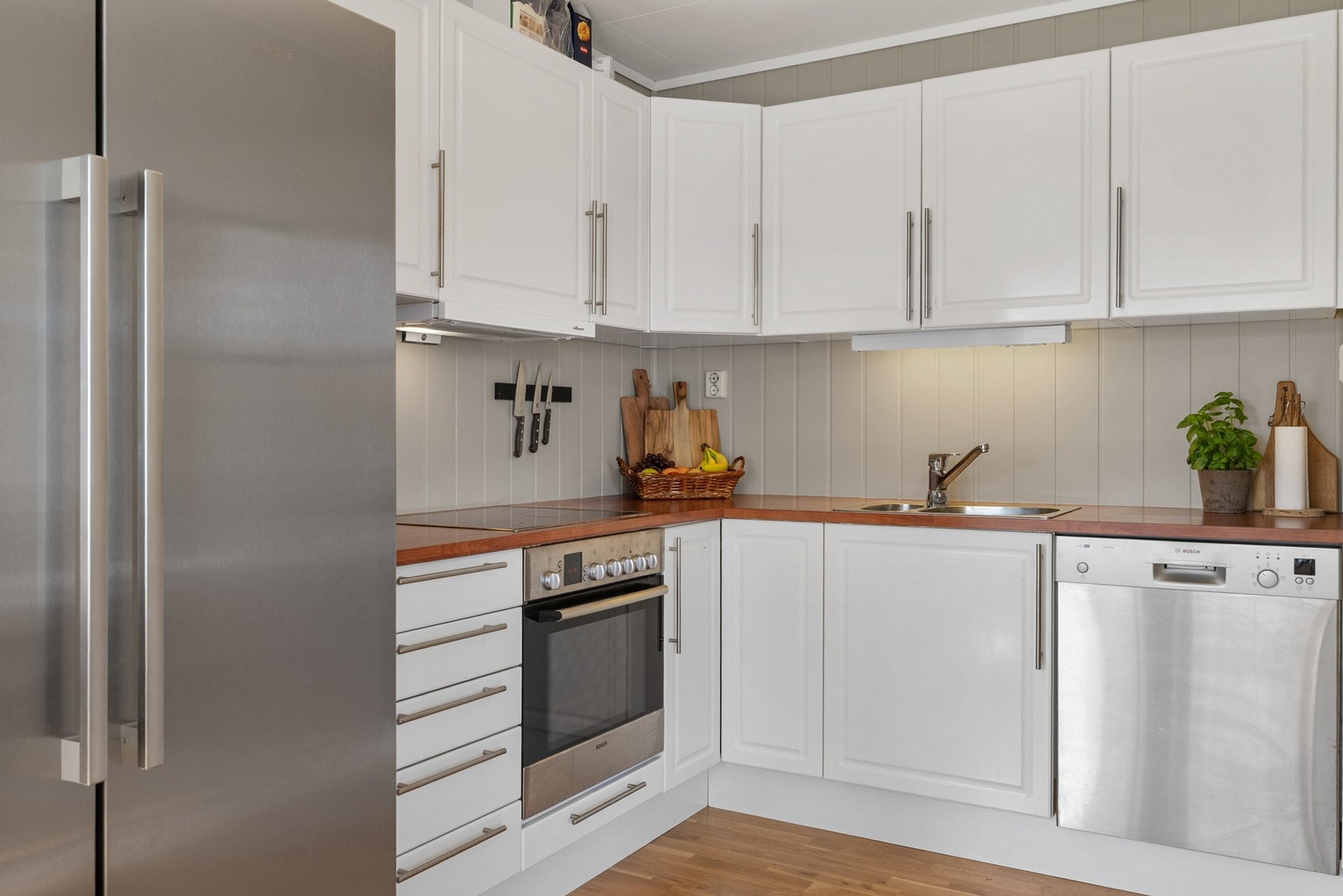 Kjøkkenet har innredning med profilerte fronter og benkeplate av laminat Galleribilde