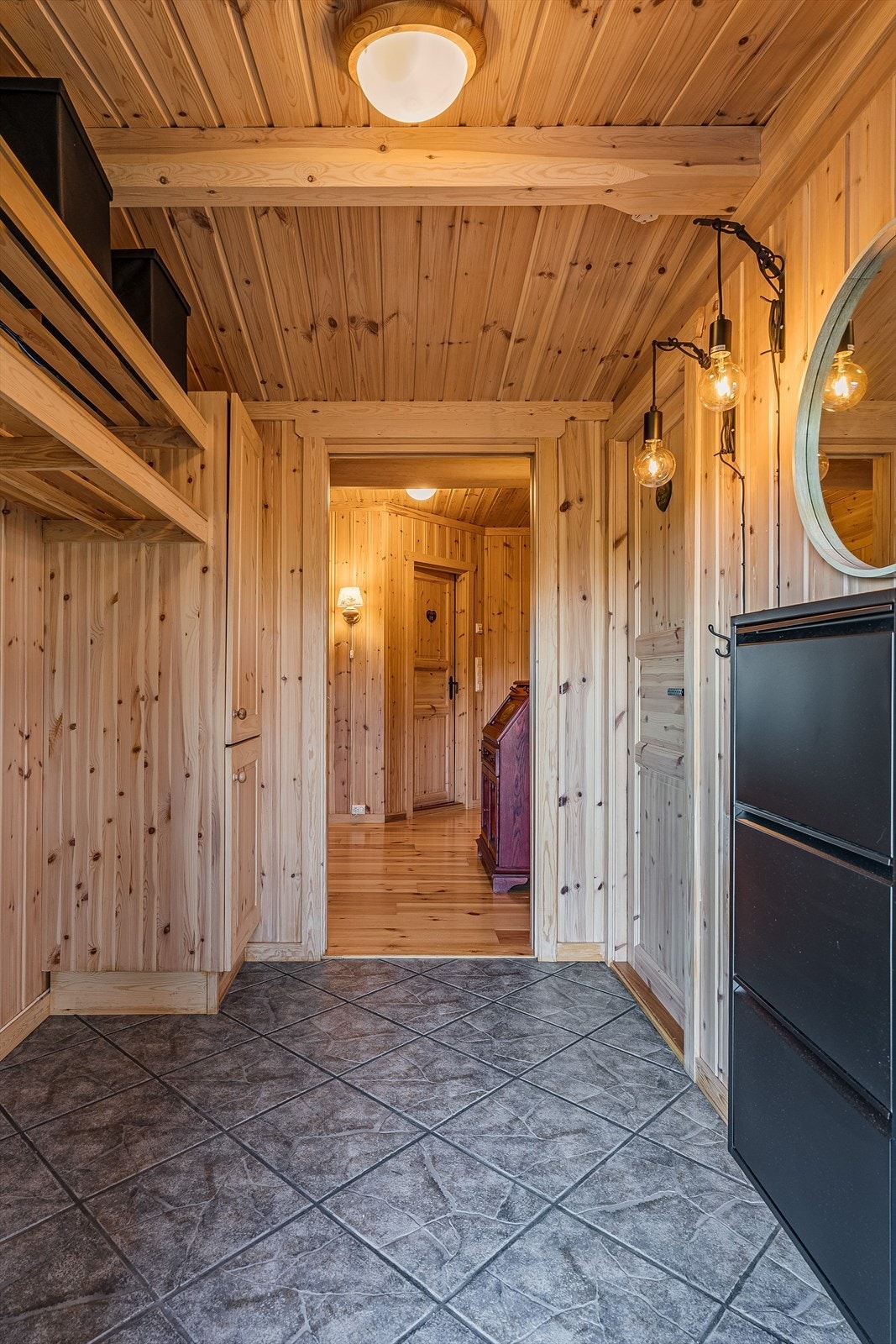 Velkommen inn! Entréen er romslig og har god plass til omkledning og oppbevaring av tøy og sko. Flislagte gulv med varmekabler bidrar til raskere tørking av sko etter en dag ute i marka eller på fjellet. Galleribilde