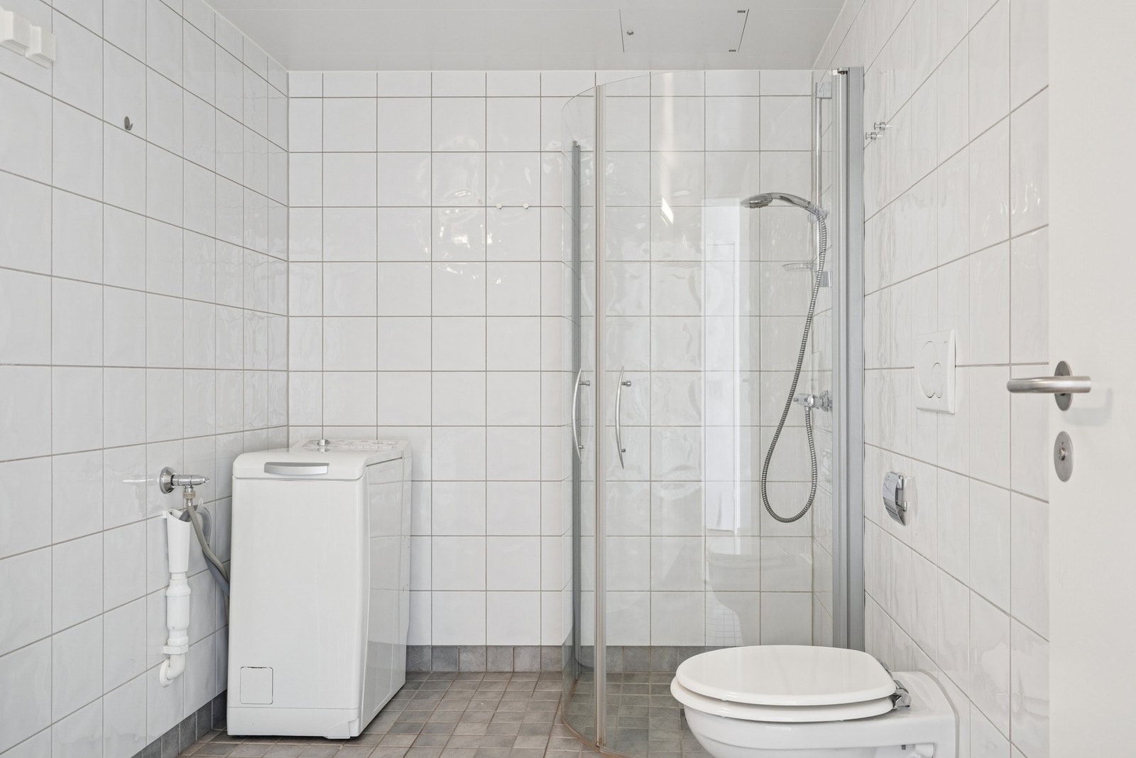 Badet er flislagt med grå gulvfliser og hvite veggfliser. Galleribilde