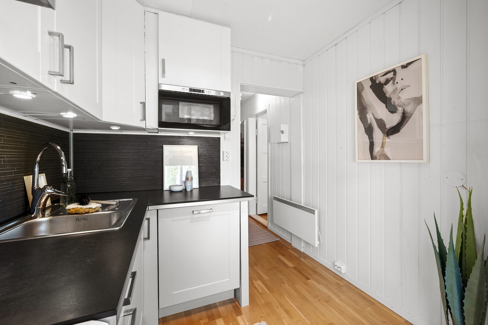 Kjøkkenet er utstyrt med integrert oppvaskmaskin og mikrobølgeovn. Frittstående komfyr følger med. Galleribilde