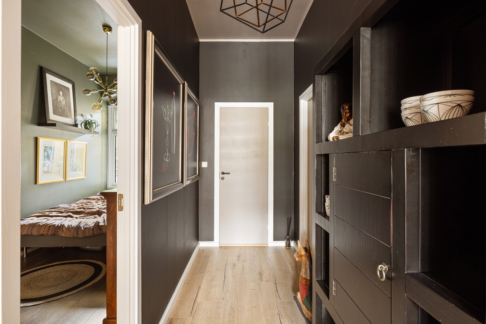 Sortmalt gang med enstavs laminat på gulv og god takhøyde. Galleribilde