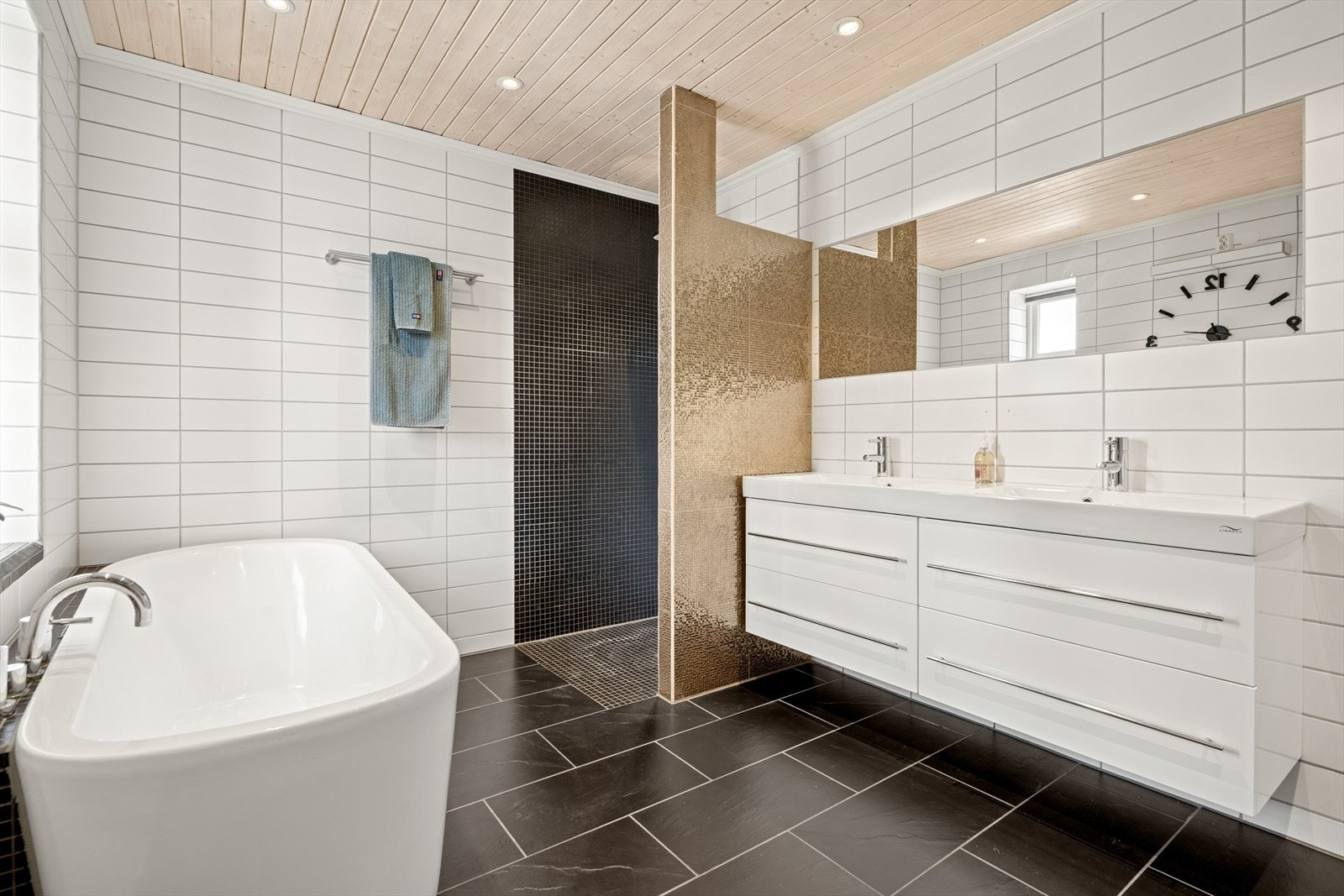 Rommet har baderomsinnredning med dobbel heldekkende servant og underskap med skuffer, veggmontert toalett, badekar og dusjhjørne. Galleribilde