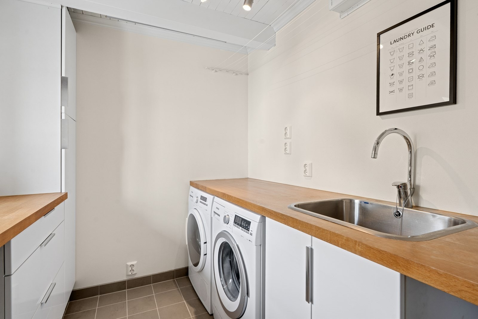 Ved kjøkken er praktisk vaskerom med praktisk innredning for både god oppbevaringsplass og arbeidsbenk. Opplegg og plass for vaskemaskin/tørketrommel i nisje. Galleribilde