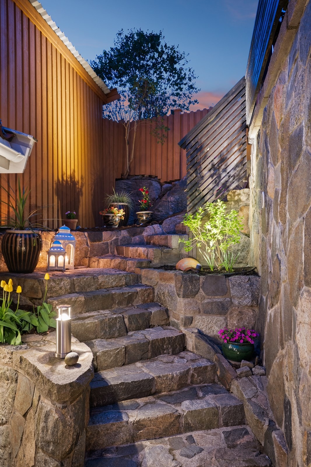 Stig på - veien opp til takterrassen i pen steintrapp med belysning og beplantning Galleribilde