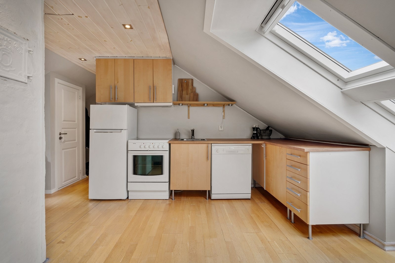 Kjøkkenet, fra IKEA, finner sin velegnede plass i enden av rommet og har folierte skrog, slette fronter og laminert benkeplate. Galleribilde