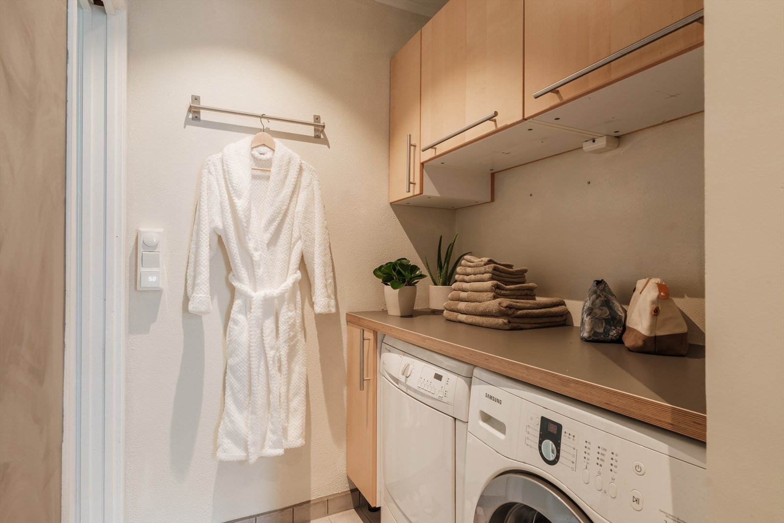 Det er opplegg for vaskemaskin med overbygde skap og benkeplate. Her har du god plass til å organisere klesvasken. Galleribilde