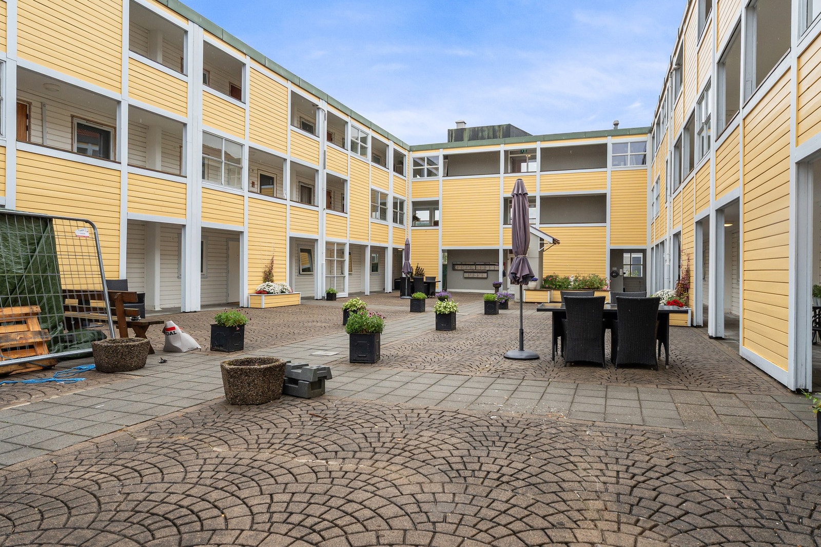 Meget trivelig atrium som benyttes av beboere. Heis innerst på plassen. (vinduer og dører byttes i borettslaget nå, og de er ferdige i leiligheten ) Galleribilde