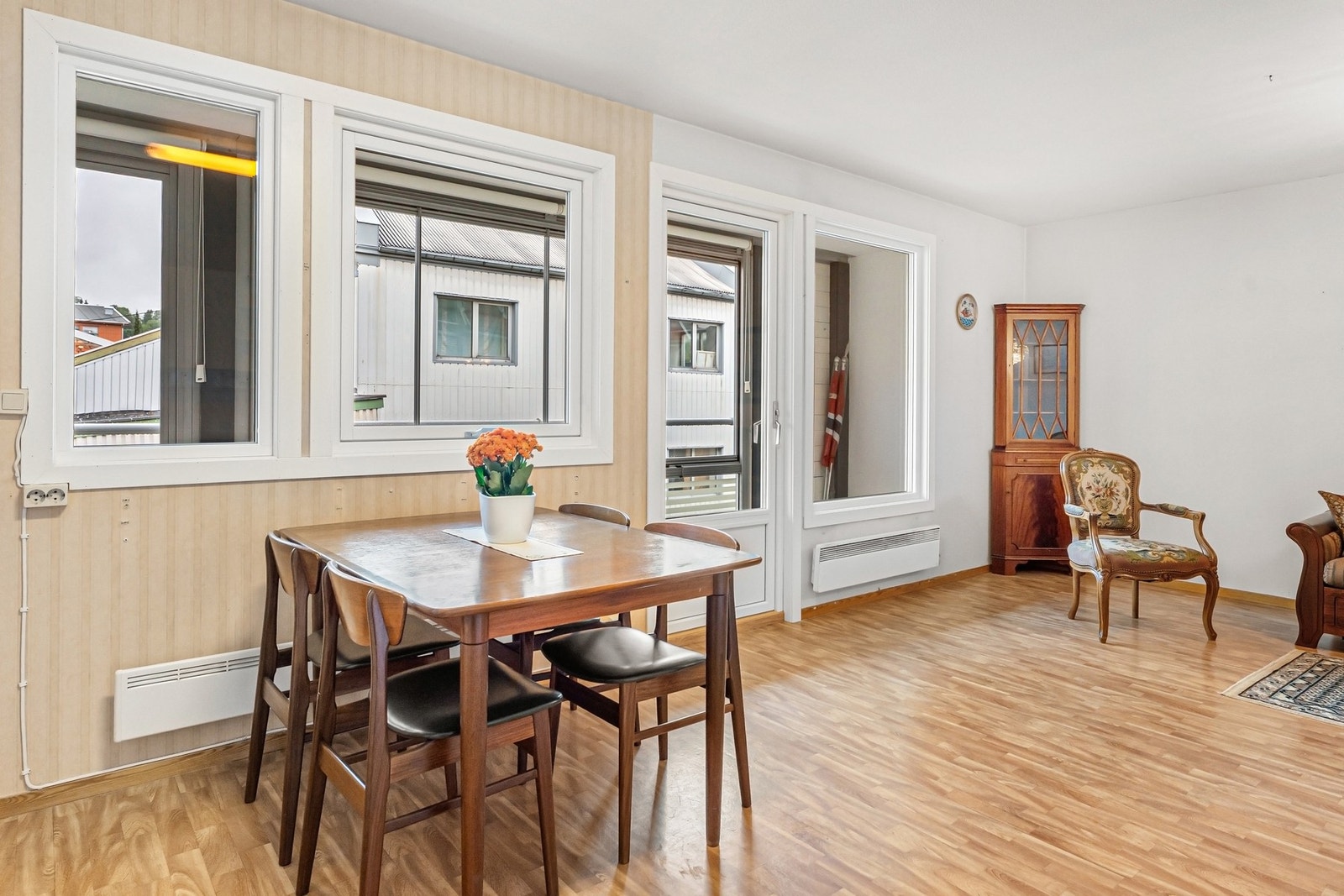 Stue med spiseplass og utgang til innglasset balkong. Det er satt inn nye vinduer og verandadør. Galleribilde