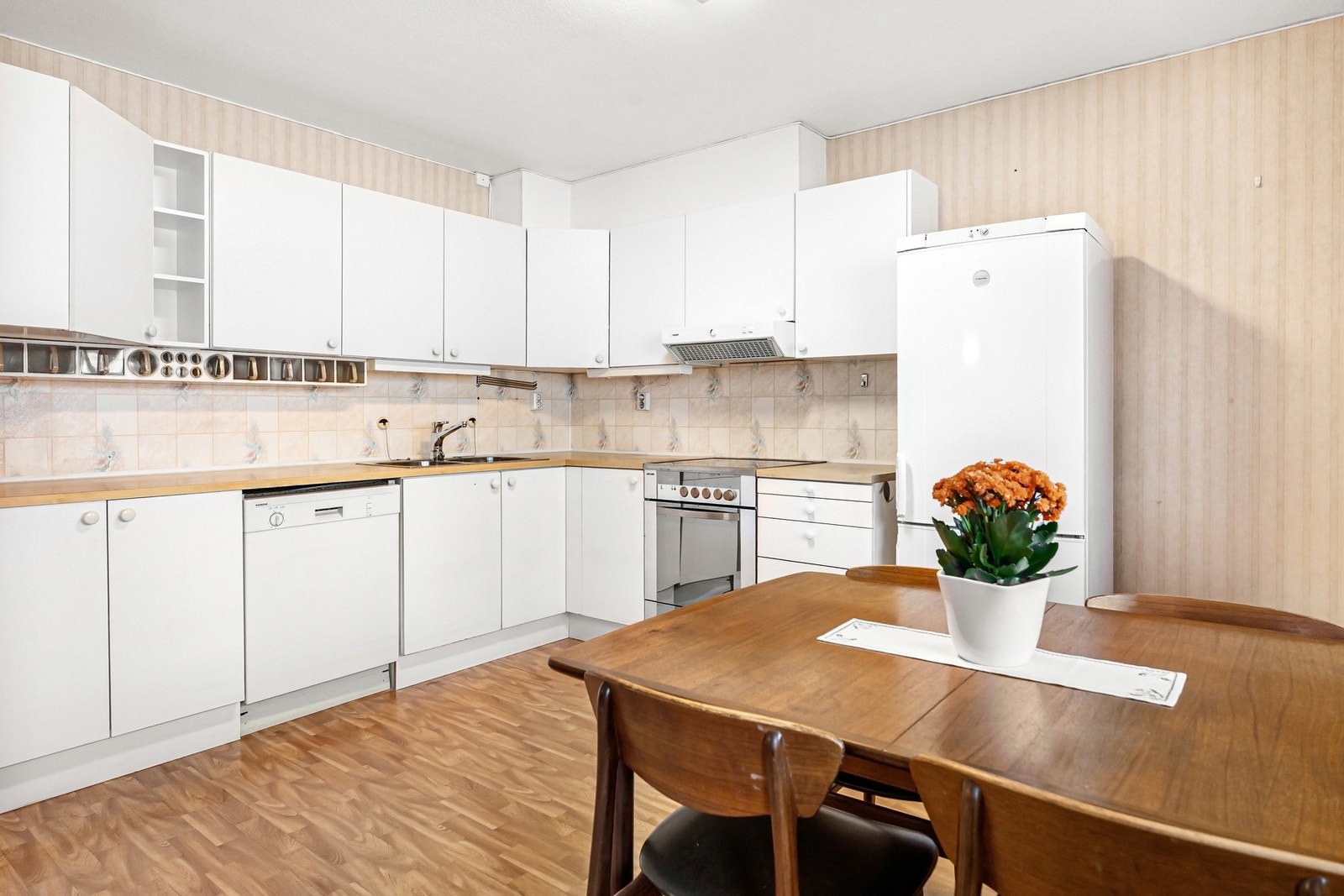 Kjøkken har hvit slett innredning fra byggeår med avsatt plass til hvitevarer. Galleribilde