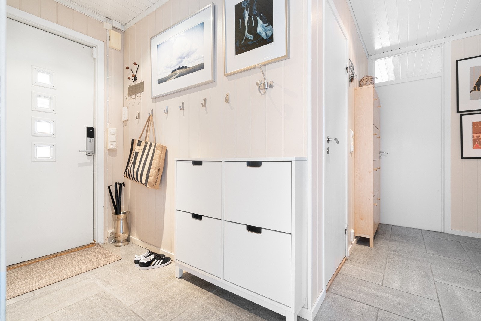 Lys og innbydende og romslig gang med plass til oppbevaring. Galleribilde