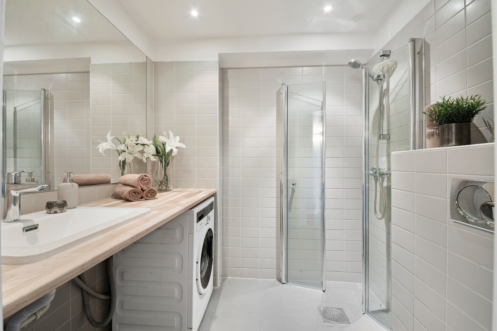 Lyst, flislagt bad fra 2006 utstyrt med dusjhjørne, vegghengt toalett, opplegg til vaskemaskin og elektriske varmekabler i gulvet. Galleribilde