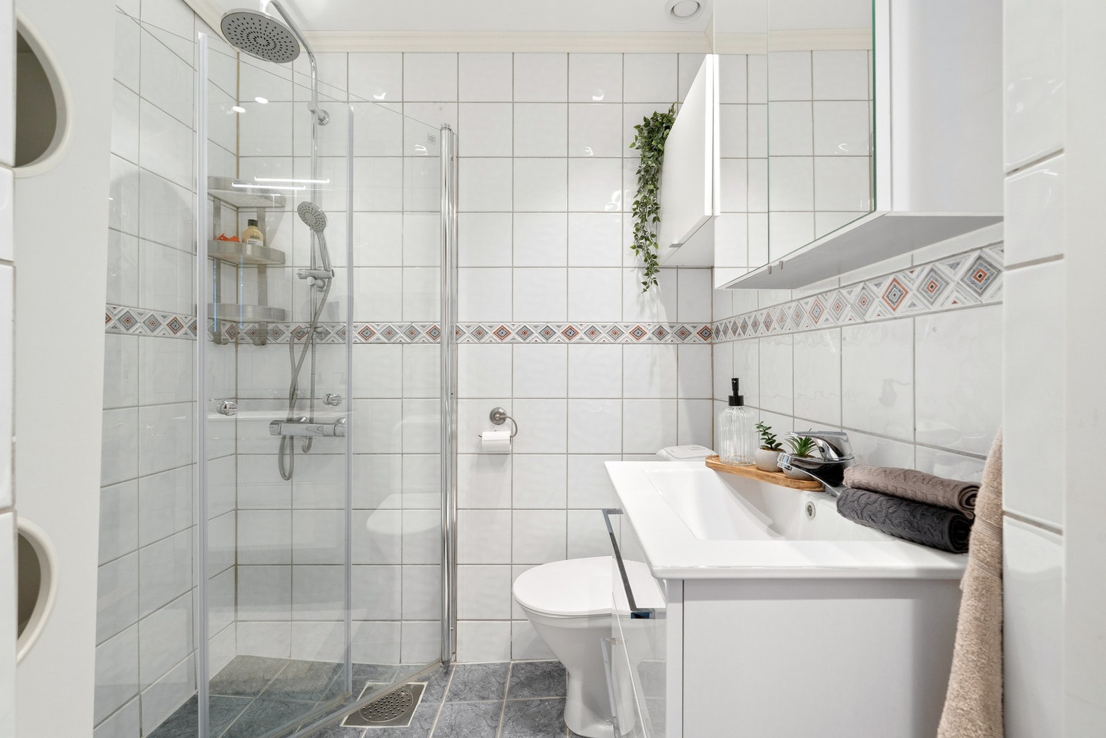 Pent flislagt bad med dusjhjørne med innnfellbare dusjdører. Galleribilde