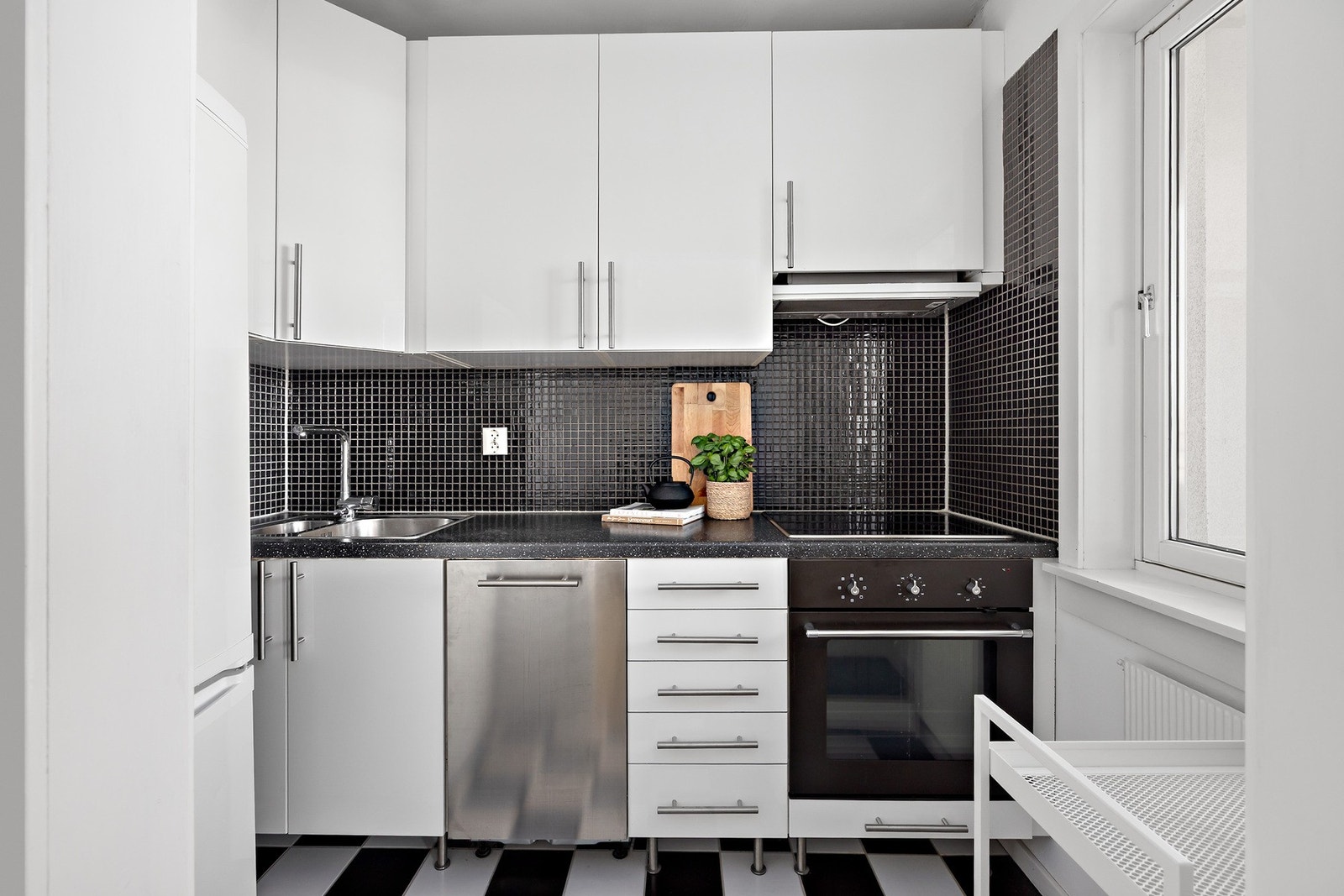 Kjøkkeninnredning fra 2006 med glatte fronter og laminert benkeplate. Oppvaskkum med ett-greps armatur. Flislagt flate mellom benkeplate og overskap. Kjøleskap med fryser, oppvaskmaskin, stekeovn og platetopp Galleribilde