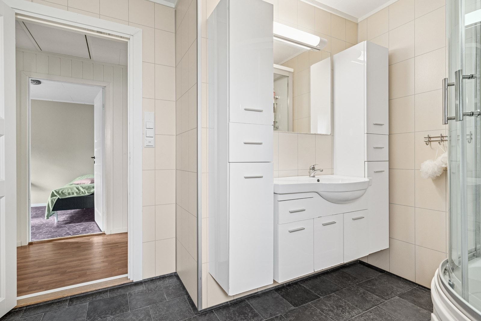 Baderom i første etasje har vinylbelegg på gulv med varmekabler og baderomsplater på vegger. Galleribilde