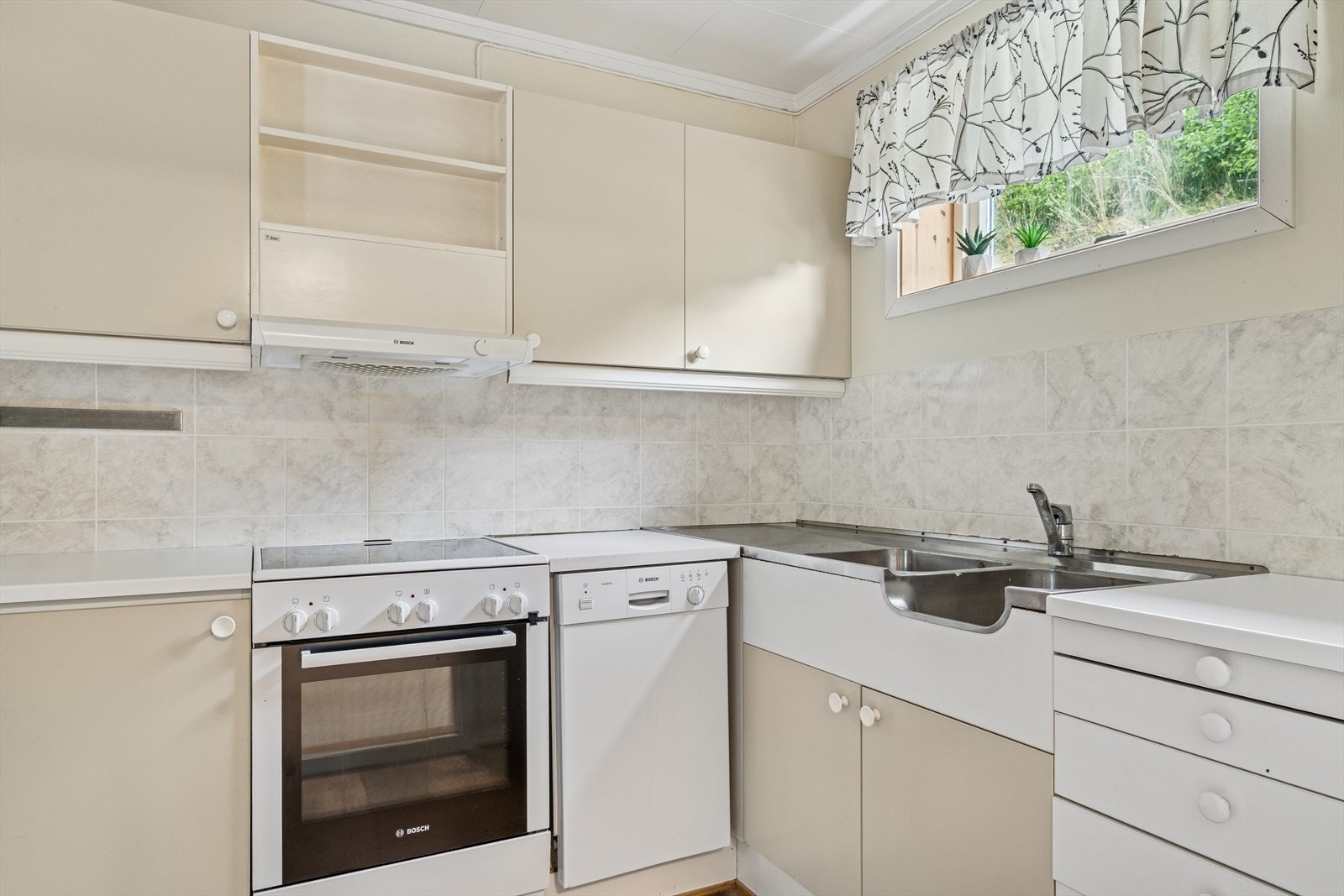 Kjøkkeninnredning med malte glatte fronter, laminat benkeplate, samt dobbel stålvask med benkebeslag. Galleribilde