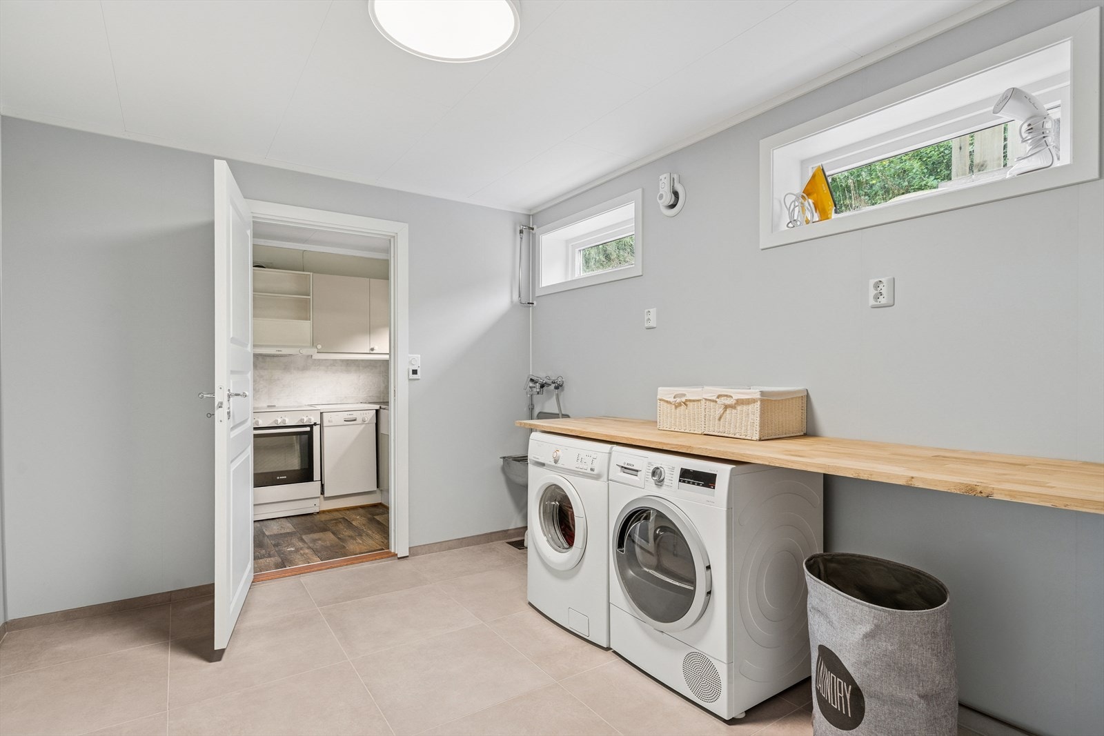 Rommet er utstyrt med utslagsvask i stål, benk i heltre, samt opplegg for vaskemaskin og tørketrommel. Galleribilde