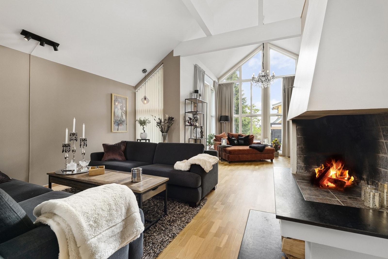 Lys stue med høyt under taket og stilrent interiør - et elegant og harmonisk rom som kombinerer moderne design med luftig atmosfære. Galleribilde