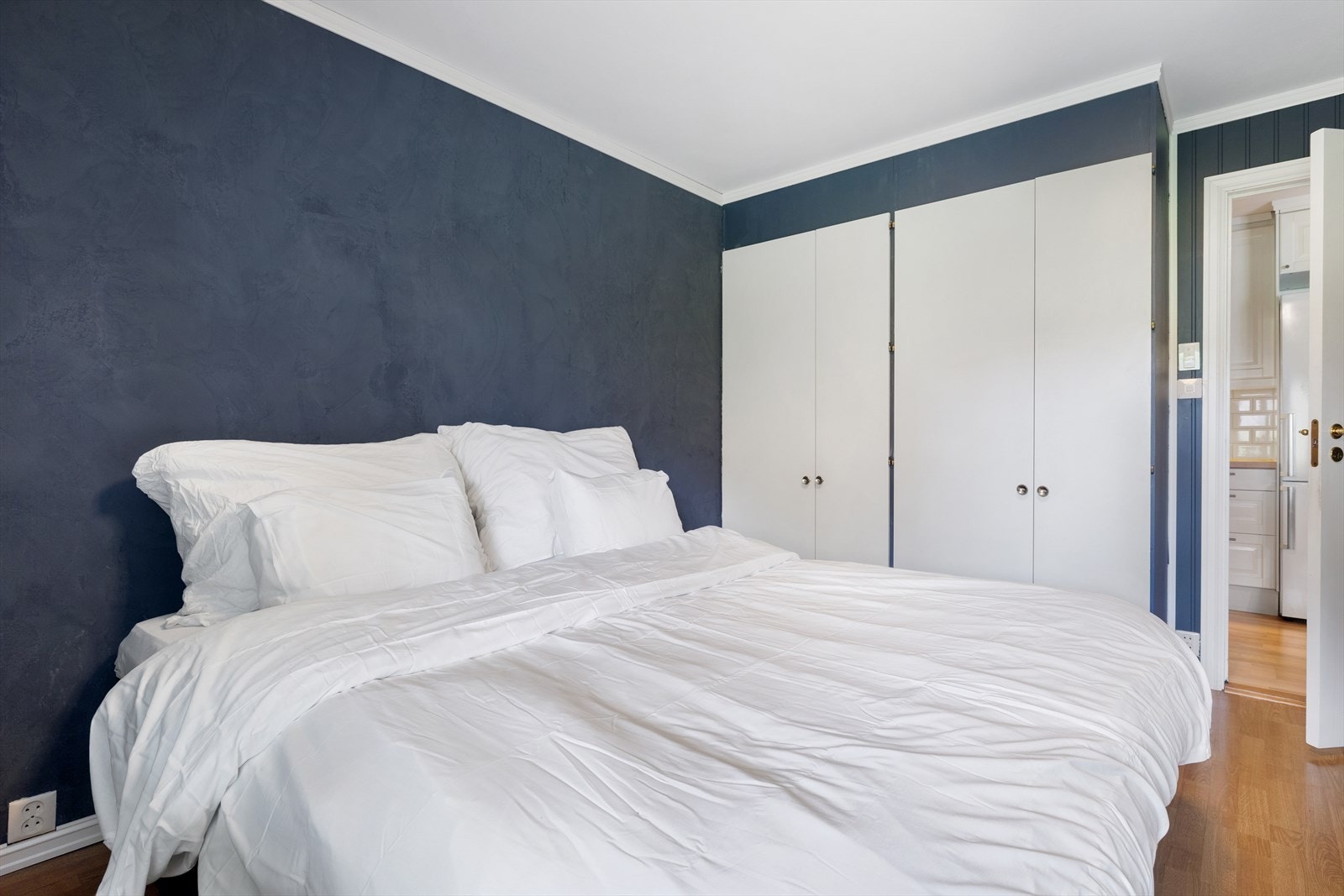 Romslig soverom med plass til dobbeltseng, kommode og innebygd garderobeskap Galleribilde