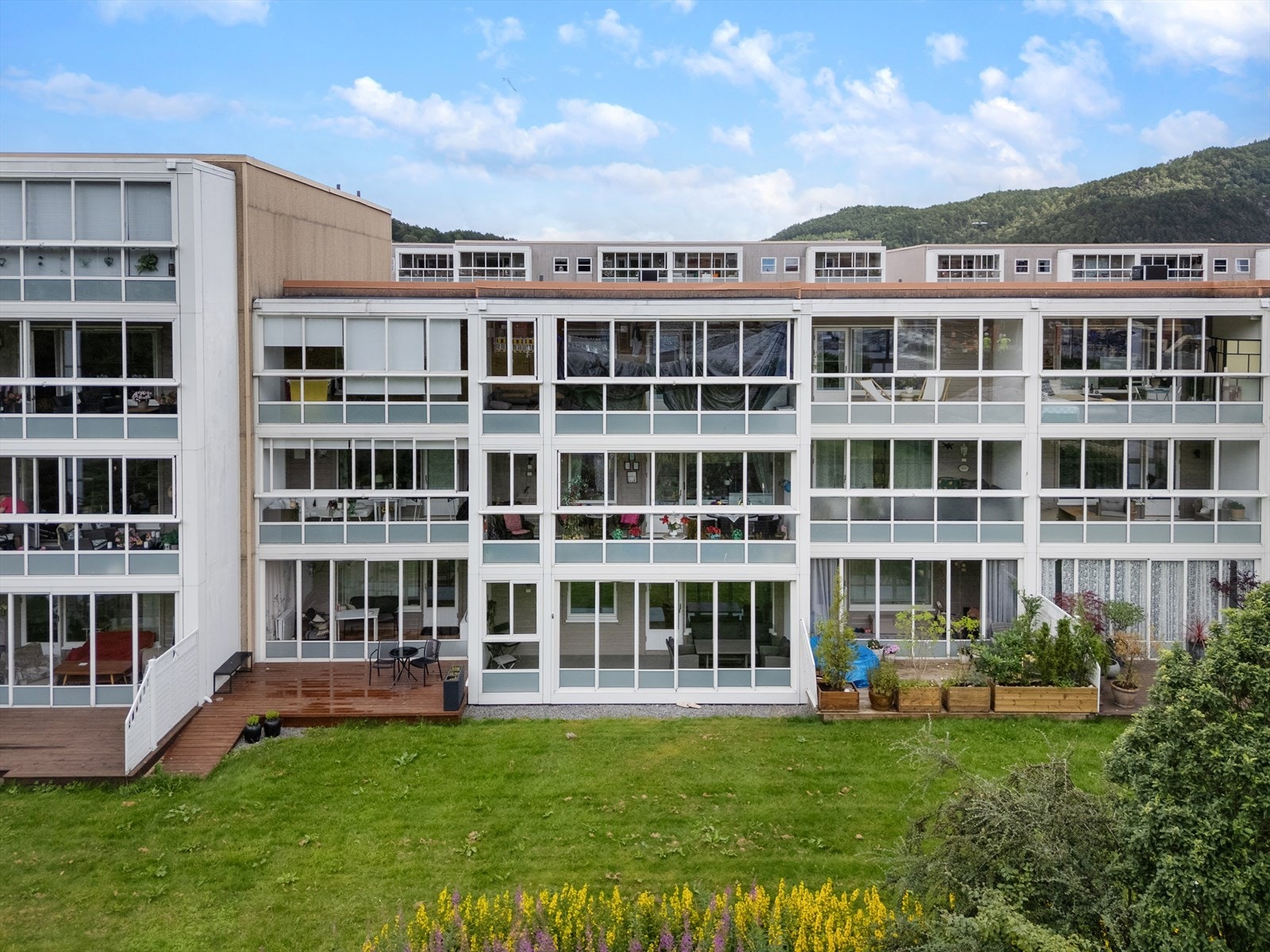 Tomten er pent opparbeidet med asfalterte stikkveger, plener, parkområde og lekeplass Galleribilde