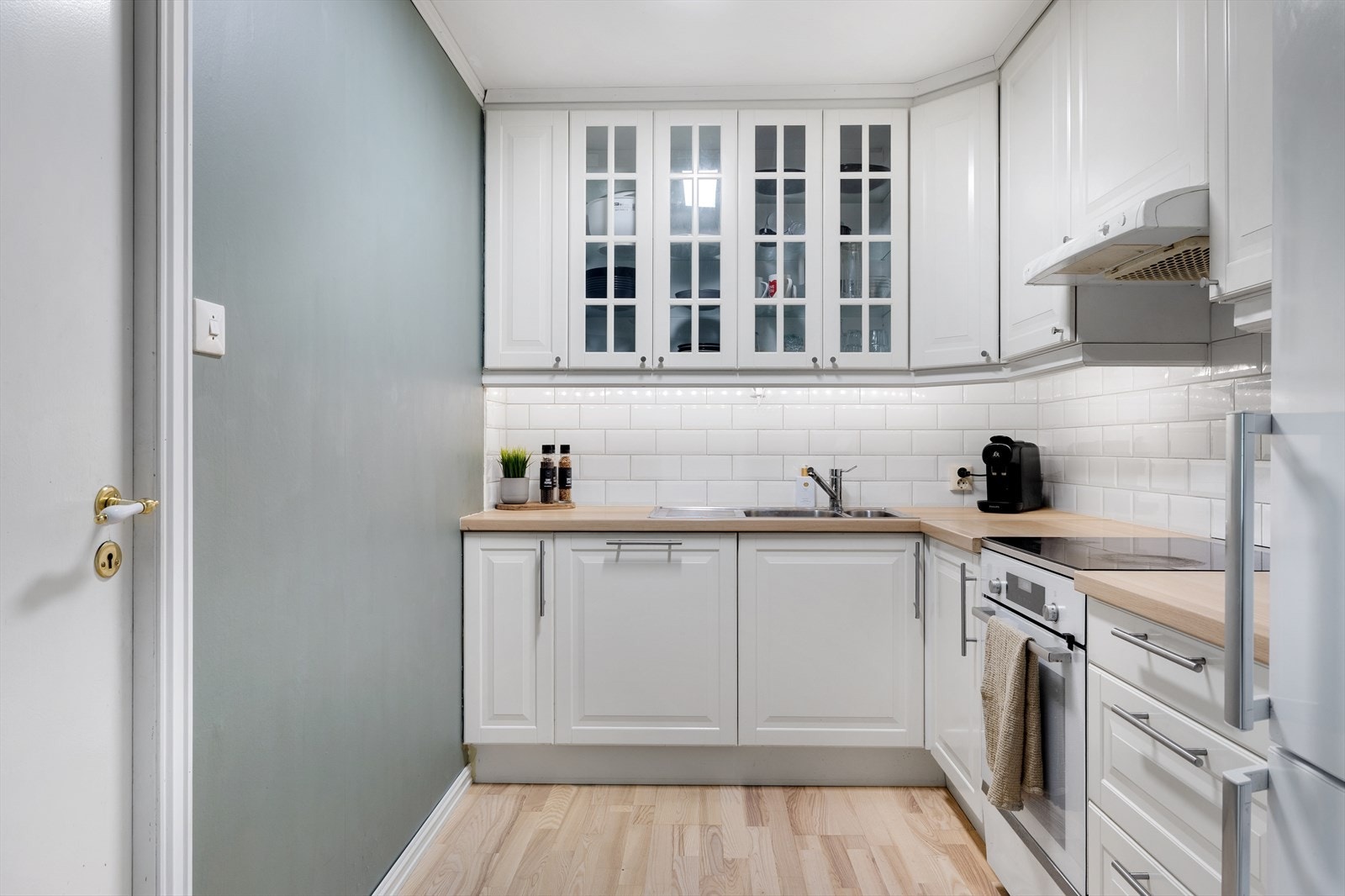 Ikea-kjøkken fra 2013 med profilerte fronter, laminat benkeplate og fliser over benk Galleribilde