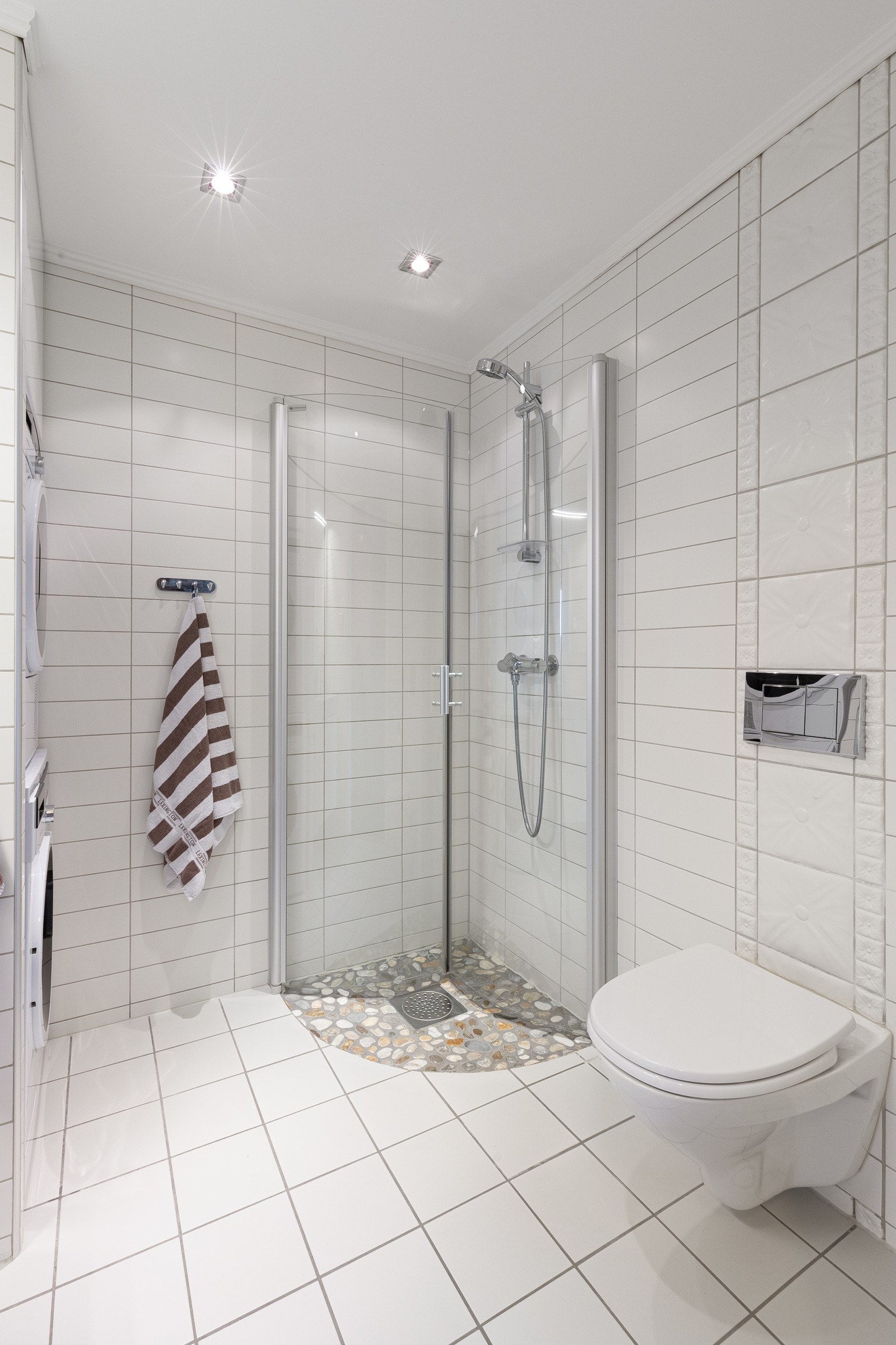 Bad med dusjhjørne og vegghengt toalett Galleribilde